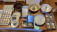 All seventeen assorted baking pans laid out on countertop