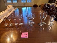 All twelve assorted clear glass stemware pieces lined on table