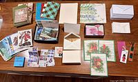 Overview of assorted greeting cards, postcards, envelopes, notebooks, bookmarks and stamps spread on table