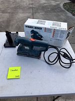 Sander with cord, dust port adapter and box on table