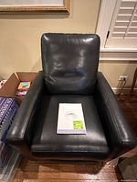 Front view of black leather power recliner chair showing overall design and upholstery