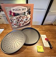 Box, two pans, pizza cutter displayed