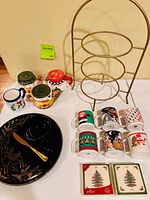 All items arranged on table including mugs, plate stand, coasters, plate, bowl and spreader