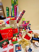Full lot showing wrapping paper rolls, gift boxes, bags, ribbons, tags and filler