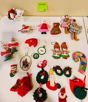 All ornaments laid out on table showing variety of plush, fabric, cross-stitch and crocheted pieces