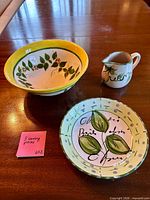 Top view of plate, bowl, and creamer showing hand-painted designs