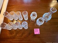 Angle view of eight tall glasses, two snifters and decanter with stopper