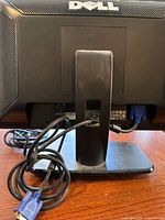 Rear view of Dell monitor on stand showing VGA cable and model label area