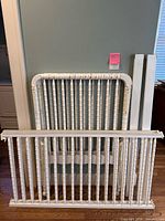 Disassembled crib parts: headboard, footboard, side panels with spindles, support rails