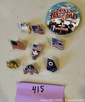 Top view of all pins including Dukes of Hazzard button and nine smaller enamel lapel pins