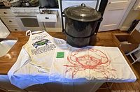Stock pot, apron and tea towel displayed on countertop