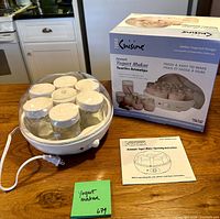 Yogurt maker with jars, power cord, manual and box on table