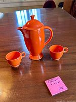 Coffee pot with lid and two mugs on table