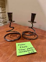 Front view of both Fisher silver-plated spiral candlesticks on tabletop
