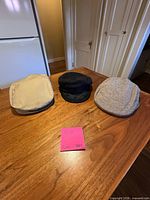 Beige, black and grey tweed Greek fisherman caps on table