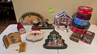 All items laid out together showing plaques, tins, figurines