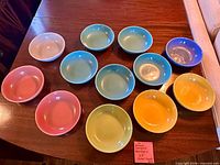 Overhead view of twelve Homer Laughlin Harlequin 7.25" salad bowls in assorted colors on table