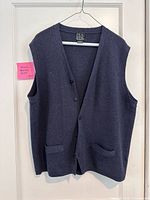 Front view of navy Jos. A. Bank button-front vest hanging, showing pockets and buttons