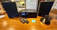 Front view of JVC receiver, Sony speakers, remotes and AR accessory base