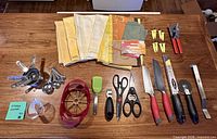 Full layout of all kitchen utensils, knives, linens and accessories on table