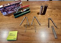 Overview of nut-cracking tools including boxed The Cracker device, three hinged nutcrackers, five picks and wooden sleeves