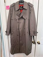 Full view of trench coat on hanger showing front, color, buttons, epaulettes, sleeve straps