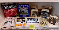 All eleven books displayed on shelf showing fronts and spines