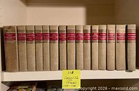 Front spines of the 15 beige cloth Classics Club hardcover books on shelf