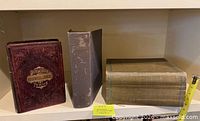 All three cloth-bound hardcover books on shelf