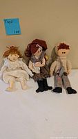 Front view of three cloth rag dolls showing outfits, hair, and overall condition