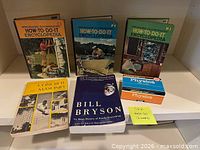 Front view of six assorted books standing and stacked