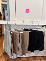 Four pairs of pants on hangers showing colors and quantity