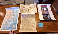 All four posters/maps laid flat showing full designs