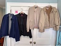 Four jackets hanging on door, front view