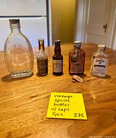 All five miniature bottles lined up on table with note