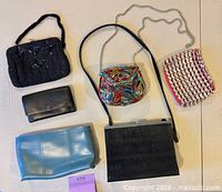 All six vintage bags and wallets laid out for full view of styles and colours