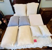 All nine pillows arranged on bed showing sizes and colors