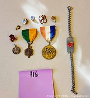 Overhead view showing all medals, pins, charm, ring and bracelet