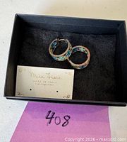 Black box containing pair of turquoise/blue stone sterling silver hoop earrings and Mia Fiore card