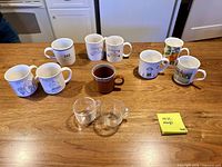All mugs arranged on countertop showing designs and condition