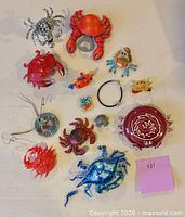 All thirteen crab and sea life themed ornaments and figurines laid out for overview