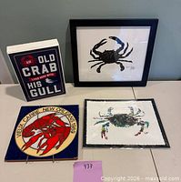 All four crab-themed wall decor items arranged on table
