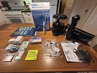 Overall lot on countertop showing toothbrush, Waterpik unit, brush heads, toothpaste, flossers, tips, manuals