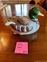 Side view of ceramic mallard duck gravy boat with ladle inserted