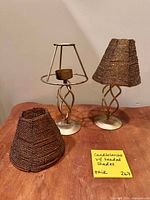 Two metal twisted candlesticks with and without beaded shades plus an additional loose shade