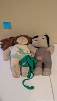 Both cloth plush dolls side by side on table
