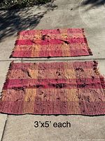 Both rag rugs laid flat outdoors showing full size, color pattern, visible wear and damage