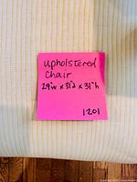 Post-it with written dimensions on chair seat fabric showing stripe pattern
