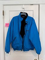 Front view of blue Patagonia bomber jacket on hanger showing full garment and zipper