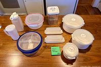All ten plastic food-storage containers with lids arranged on wooden surface